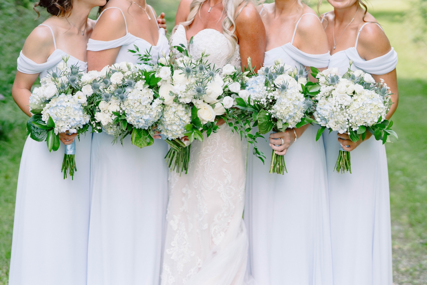 Bridal bouquet with all white roses, babies breath, soft blue hydrangeas, blue thistle, and greenery