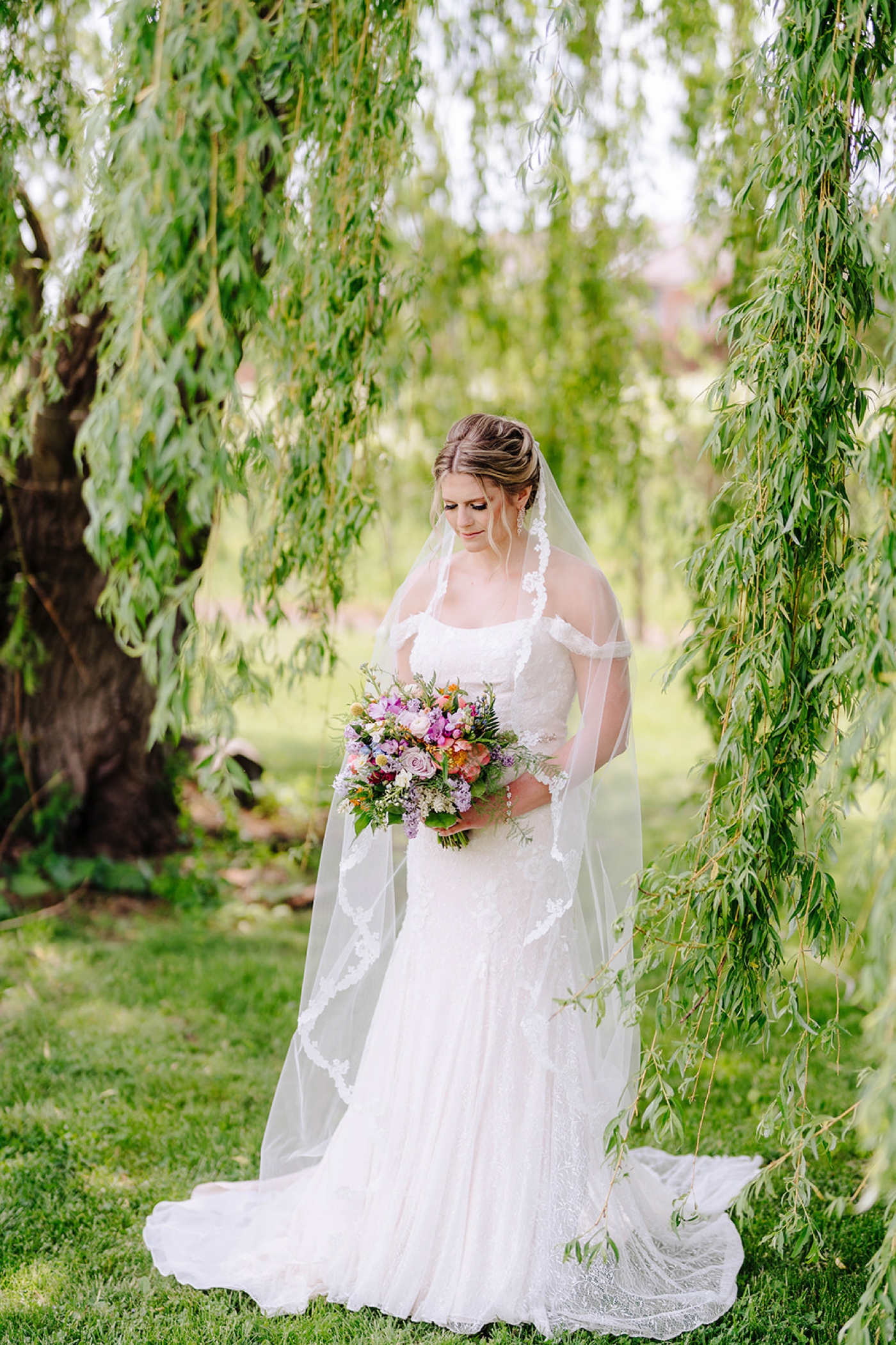 Bride in a lace off-the-shoulder wedding gown from David's Bridal