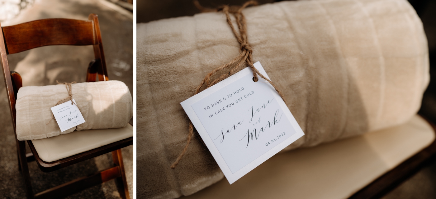 Blankets with a tag that says "To have & to hold in case you get cold" at a snowy mountain wedding ceremony