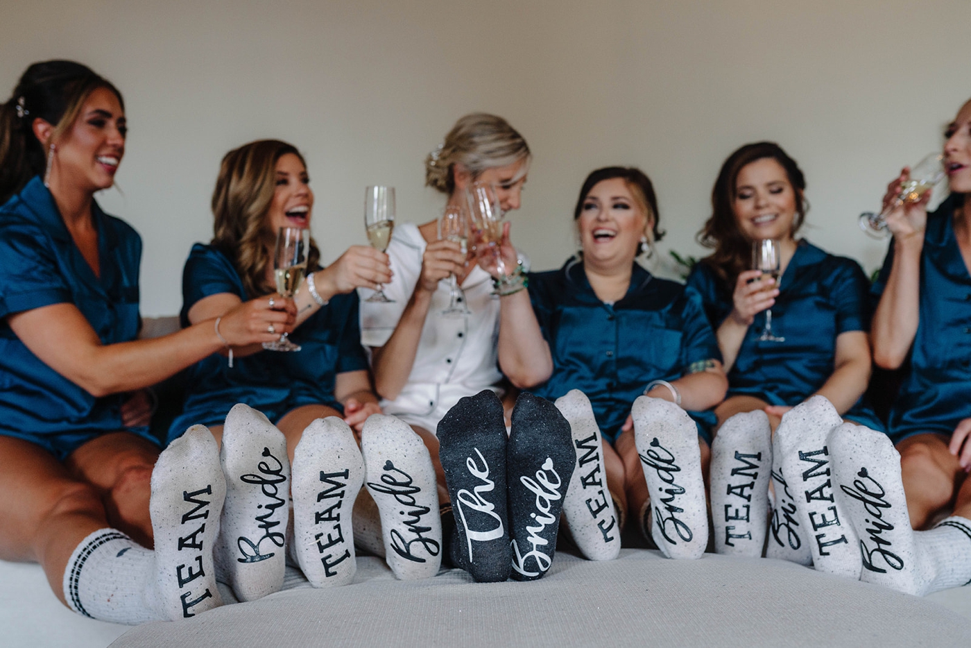 Bride getting ready with her bridesmaids in matching silk pajamas